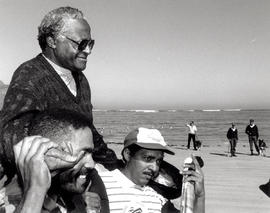Archbishop Tutu is carried aloft by supporters after stepping onto the 'whites only' Strand beach...