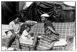 Two women and child on a couch in Brown's Farm, Khayelitsha